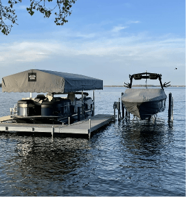 Covered boats docked on a serene lake under a clear blue sky, showcasing peaceful outdoor watercraft storage.