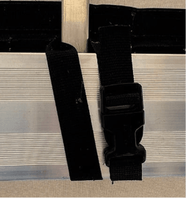 Black plastic buckle with straps attached to a silver metal frame.