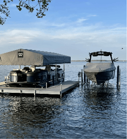 Boat and pontoon on a dock by a calm lake under a clear sky, ideal for summer leisure activities.