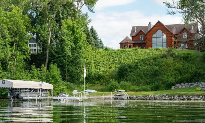 Scenic view of a lakeside property with a dock and boats